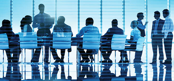 Tarifverhandlungen Menschen, die an einem Besprechungstisch sitzen