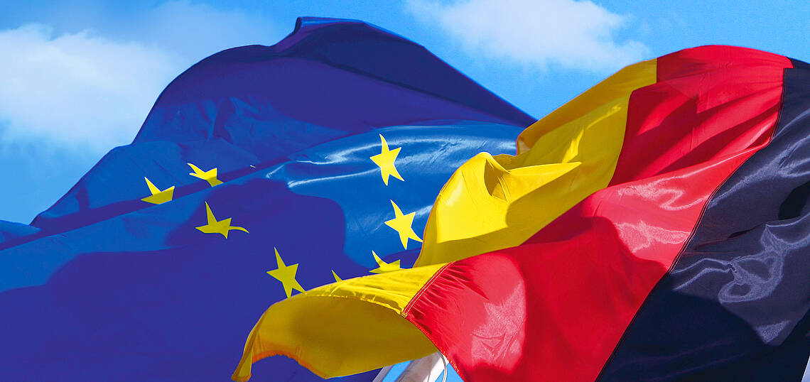 Kopfzeile „Europa – Erklärungen der Sozialpartner“ Europa- und Deutschlandflagge wehen im Wind
