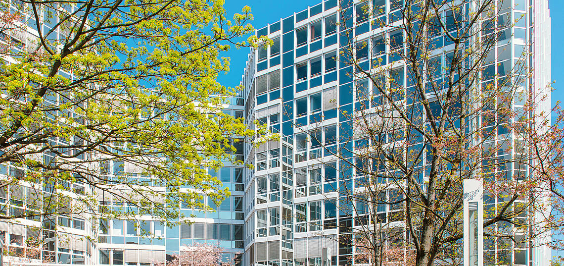 Kopfzeile „Wir über uns – Ansprechpartner“ Fassade des AGV-Bürogebäudes